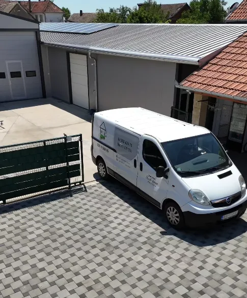 Beli kombi sa logom Fresh House u dvorištu ispred zgrade radionice