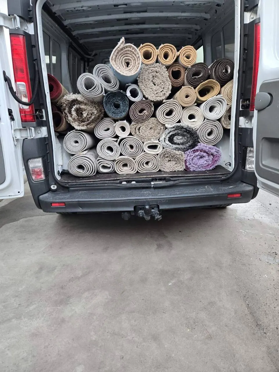 Kombi pun čistih, smotanih tepiha spremnih za vraćanje vlasnicima